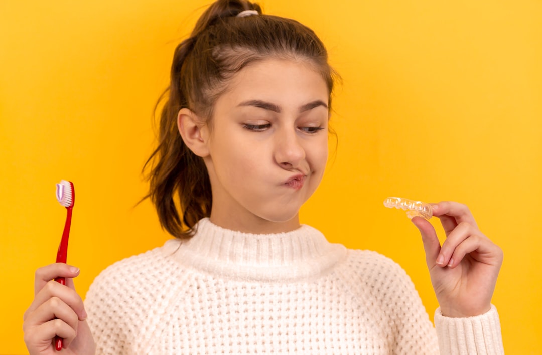 Smiling woman holding a clear oral hygiene tool