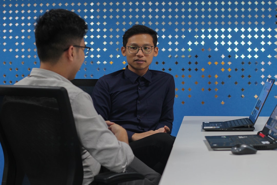 Two colleagues seated at a table in conversation